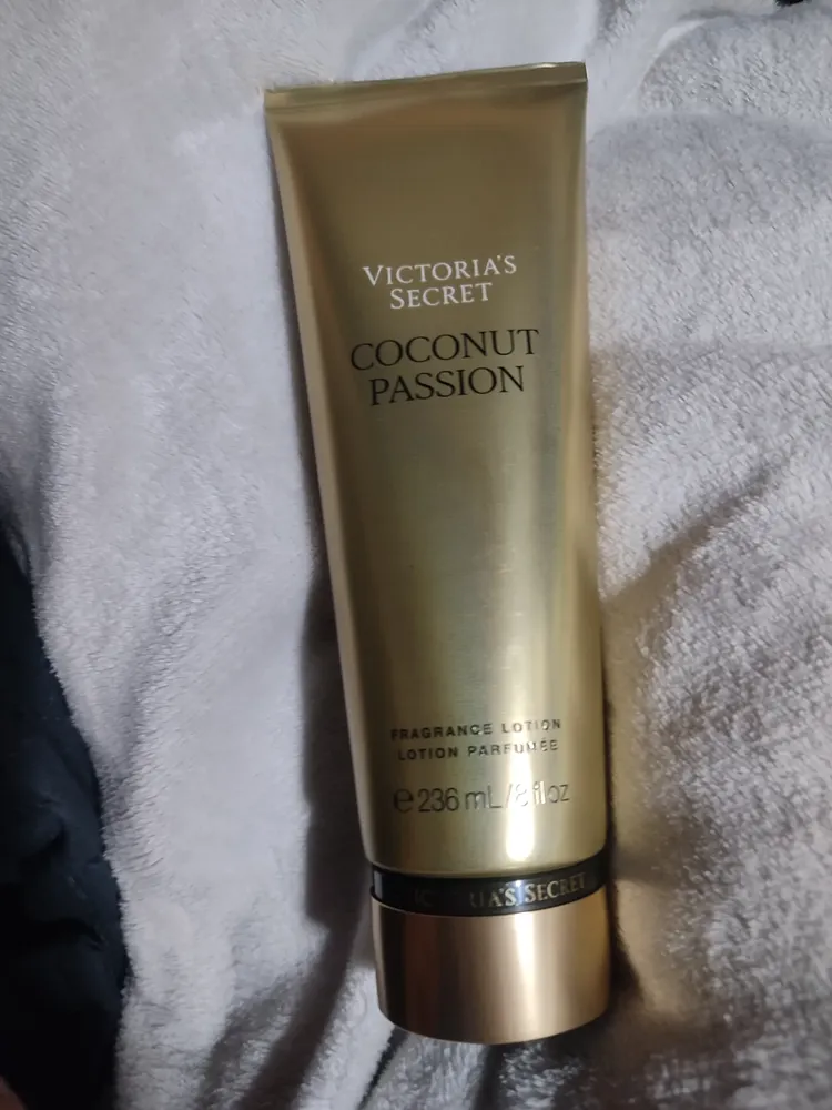 Tubo de loción corporal Victoria's Secret Coconut Passion de 236 ml sobre toalla blanca.