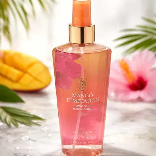 Body mist Victoria's Secret Mango Temptation de 250 ml junto a un mango fresco y una flor de hibisco.