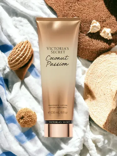 Loción corporal Victoria's Secret Coconut Passion de 236 ml sobre toalla de rayas azules y blancas.