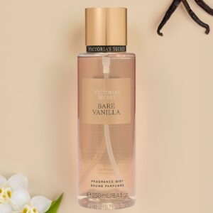 Body mist Victoria's Secret Bare Vanilla de 250 ml con vainas de vainilla y flores blancas sobre fondo beige.
