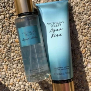 Set de body mist y loción Victoria's Secret Aqua Kiss sobre un fondo de piedras naturales.