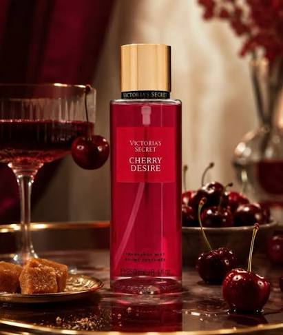 Body mist Victoria's Secret Cherry Desire de 250 ml sobre bandeja dorada con copa de licor de cereza y azúcar morena.