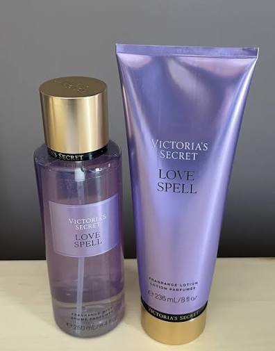 Set de body mist y loción Victoria's Secret Love Spell sobre fondo beige.