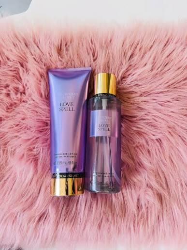 Set de body mist y loción Victoria's Secret Love Spell sobre alfombra rosa de peluche.