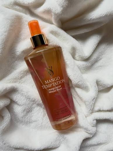 Frasco de body mist Victoria's Secret Mango Temptation de 250 ml sobre una toalla blanca.